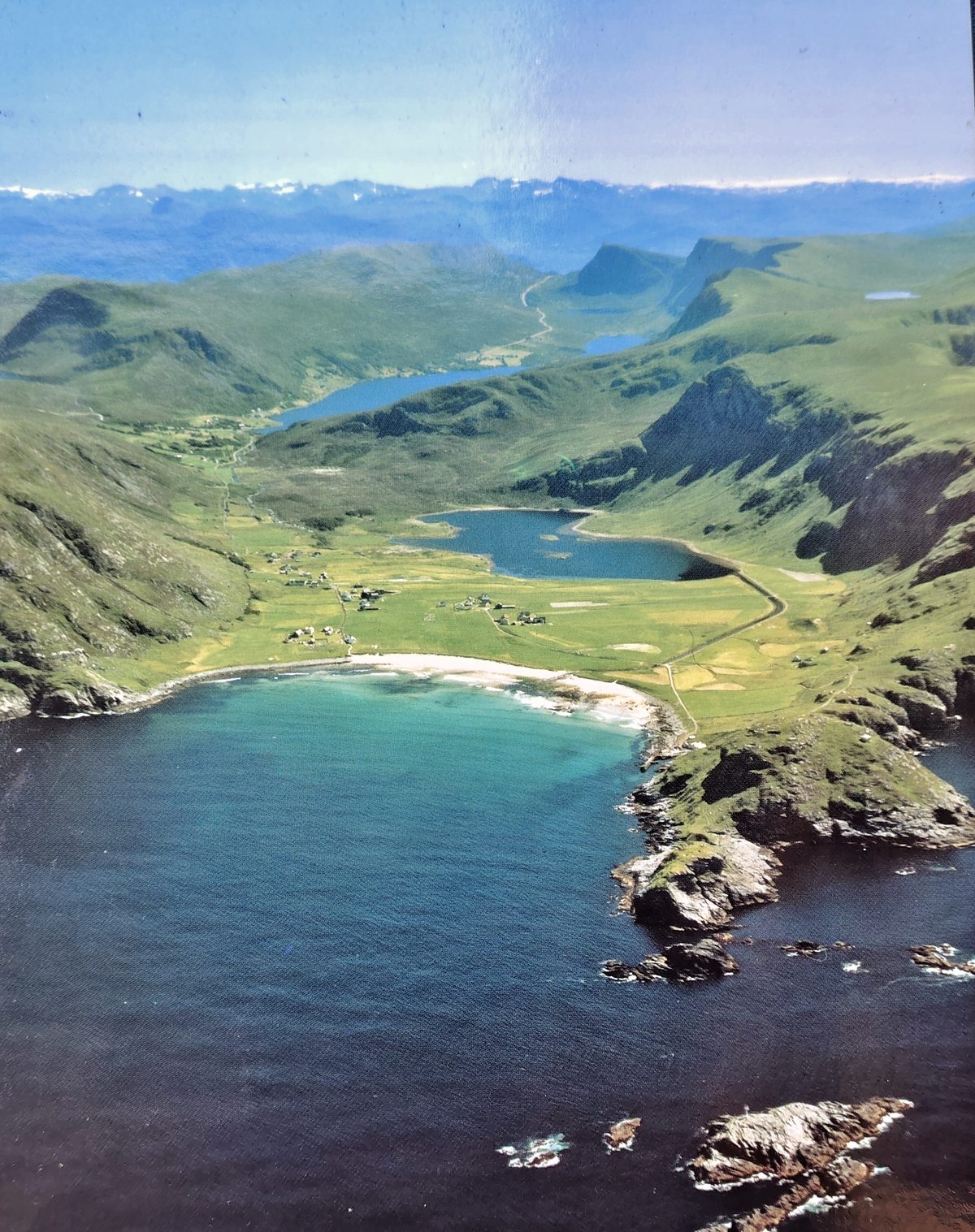 Aerial view of Ervik on the Stadlandet peninsula, Norway, showing a white-sand bay ringed by mountains and inland lakes
